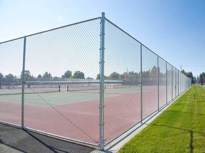 Pagar lapangan tenis berlapis polimer dengan gerbang ganda.