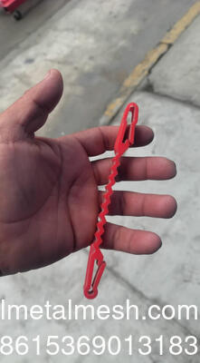 Klip Plastik Merah yang Berada di Antara Kabel Concertina dan Kabel